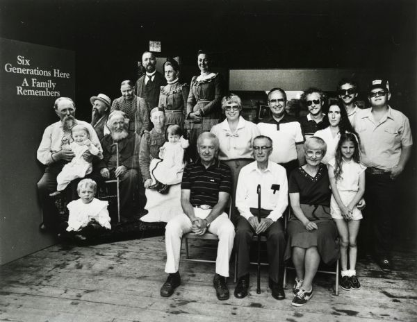 Edgar Krueger (with cane) and his family pose in front of a photograph of earlier generations of Kruegers at the opening of the "Six Generations Here" exhibit at the Wisconsin Historical Museum. Edgar also appears in the historic photograph as a small boy seated on this grandfather's lap.