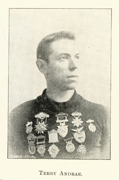 Quarter-length portrait of Terry Andrae, who is wearing several medals on his chest won in bicycle races.