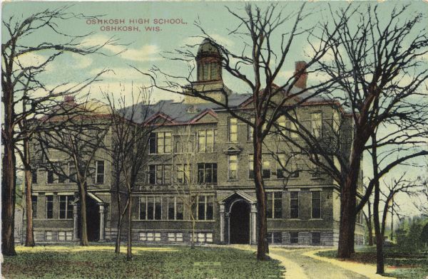 Hand-colored postcard view of Oshkosh High School in early spring. Several bare trees are on the lawn in front of the school. Caption reads: "Oshkosh High School, Oshkosh, Wis."