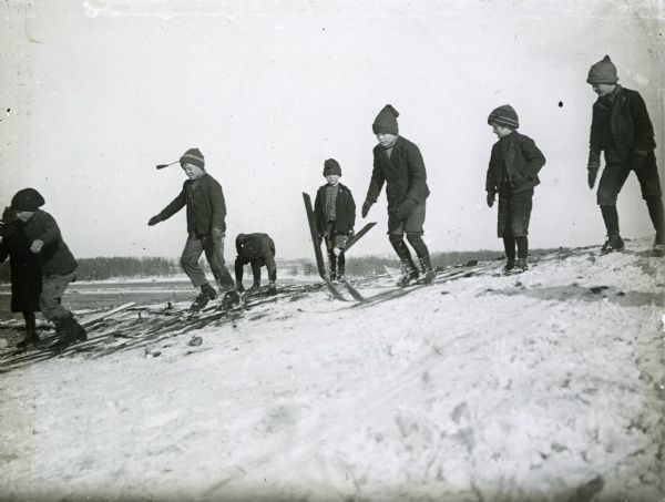 Several young children on skis at the top of a hill at a Stoughton ski meet.