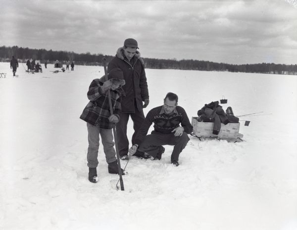 Lee Jameson, Walter Jameson, and Jim Stern clearing an ice fishing hole in Thunder Lake.