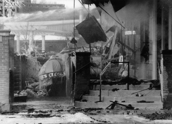 Ruins of the Barber's Closet in the Hotel Washington. Water shooting from firetruck hoses is visible in the upper left of the image, as the fire that destroyed the Hotel is still burning. Icicles have formed on the ruins.