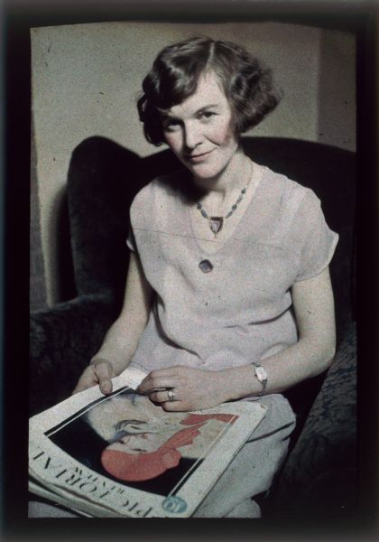 Autochrome of Genevieve (Milward) McVicar, married to Angus B. McVicar, seated in a chair and holding a copy of the "Pictorial Review."