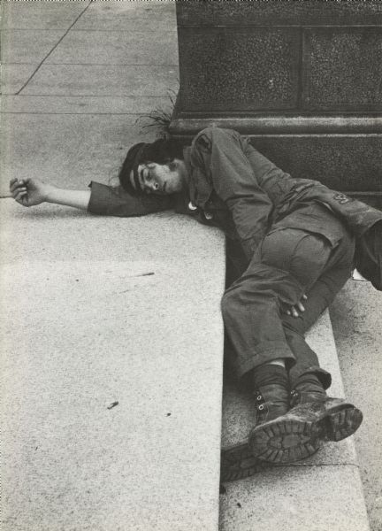 A Vietnam veteran takes a nap on outdoor concrete stairs. He is at an anti-war demonstration and took part in the Winter Soldier Hearings.