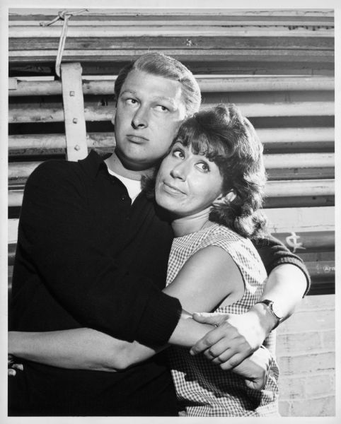 Publicity photograph, for the 1962 play "A Matter of Position," of Mike Nichols and Rose Arrick hugging. They are both looking off to one side.