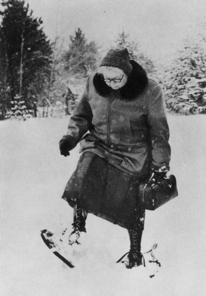 Dr. Kate Newcomb walking in snowshoes with her examination bag.