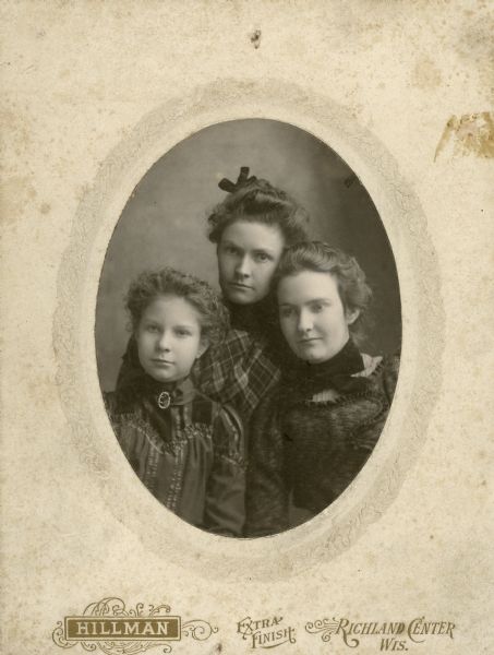 Formal oval-framed group portrait of Vida James, Ada James and Beulah James. Ada James (center back) later became active in the Wisconsin Women's Suffrage Association.