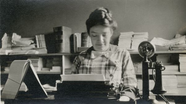 Suffragist Ada James sitting at her desk.