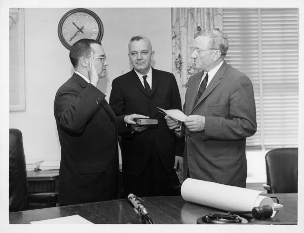 Newton Minow is sworn in as Federal Communications Commission (FCC) chairman. He has his right hand raised and the left hand on a bible as he takes the oath.