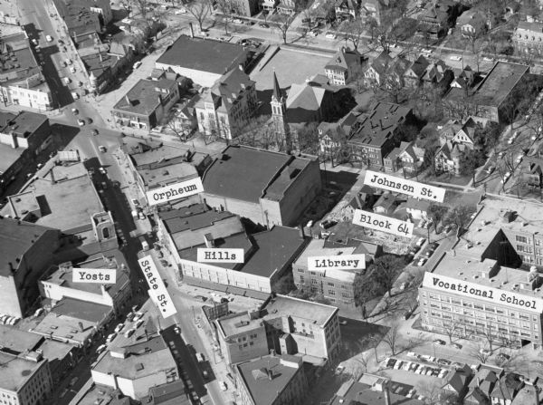 Aerial view of Madison, including Yost's, State Street, The Orpheum Theatre, Hills, the Madison Public Library, block 64 parking, East Johnson Street, and the Milwaukee area Technical College.