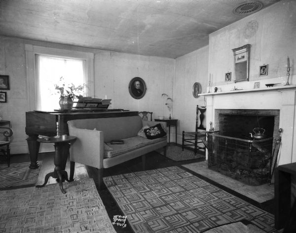 Parlor decorated in 1840s style in Ralph Warner's "The House Next Door." aka the Lovejoy-Duncan House, 11219 North Webster Street, showing piano and fireplace.
