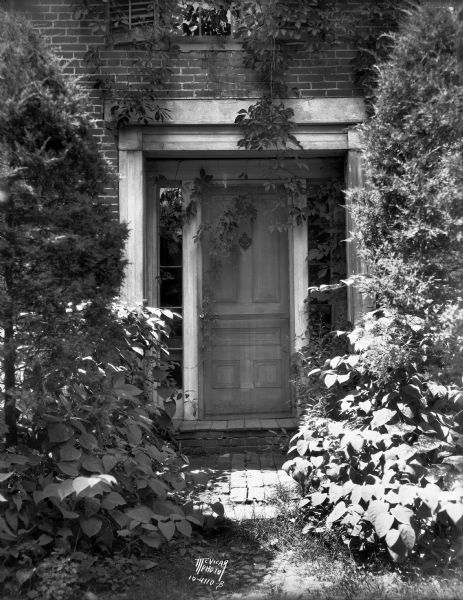 Front entrance to Ralph Warner's "The House Next Door," aka the Lovejoy-Duncan House, 11219 N. Webster Street, surrounded by vegetation.