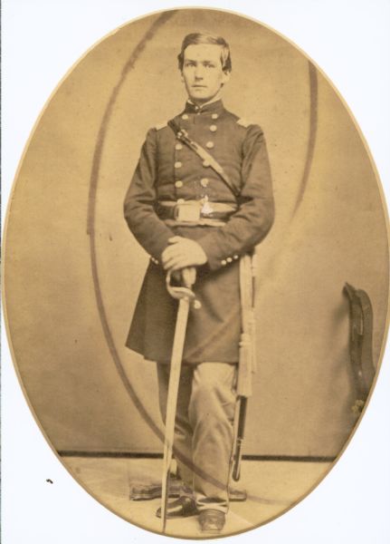 Full-length oval-framed studio portrait of William Greene, in uniform and holding his sword in front of him.