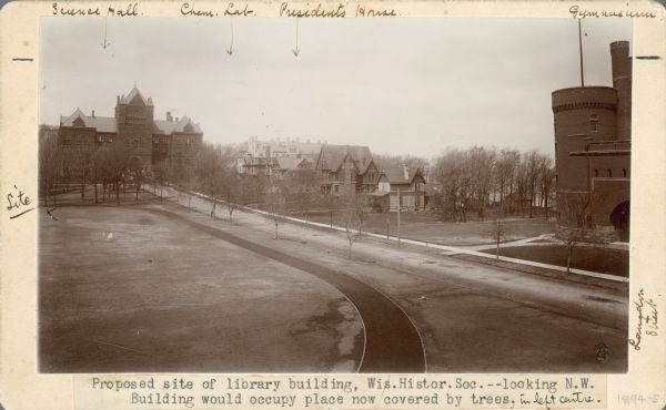Caption from photograph: "Proposed site of library building. Wis[consin] Histor[ical] Soc[iety].--looking N.W. Building would occupy place now covered by trees, in left centre."

The view looks over an open space with a curved path that runs along Langdon Street. University of Wisconsin-Madison buildings include Science Hall, Chemistry Lab, the President's House, and the Red Gym (Gymnasium).