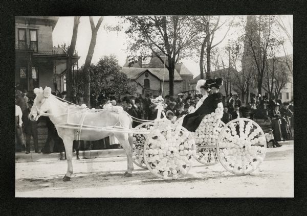 Mrs. Beercroft, née Lucy Hoven, and her mother in a decorated carriage in front of the Hoven family home on Mifflin Street. A crowd stands on the sidewalk.