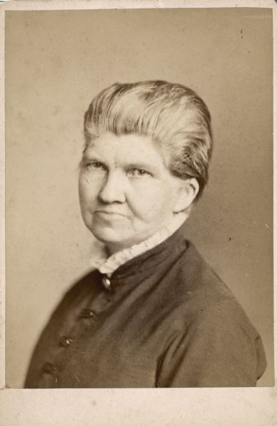 Head and shoulders portrait of Elmina Drake Slenker. She is wearing a dark dress with a high, lace collar.