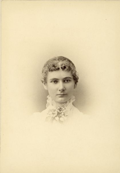 Vignetted head and shoulders portrait of Florence Bascom.