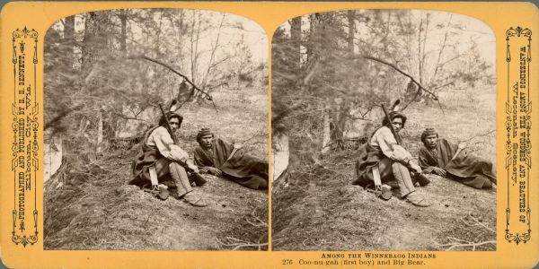 Coo-Nu-Gah (First Boy) and Big Bear, two Winnebago Indians, sitting and reclining on the ground. Both men are looking at the camera and are wearing blankets. The man on the left is holding a rifle, which is resting on his shoulder. Text at right: "Wanderings Among the Wonders and Beauties of Wisconsin Scenery."