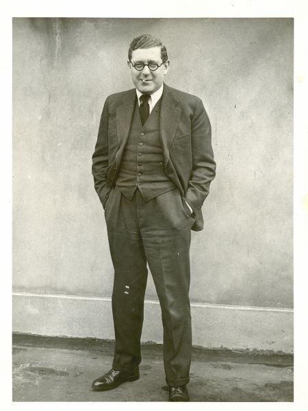 Full-length candid portrait of Leo Lania (born Lazar Herrmann) standing with his hands in his pockets and a cigarette in his mouth.