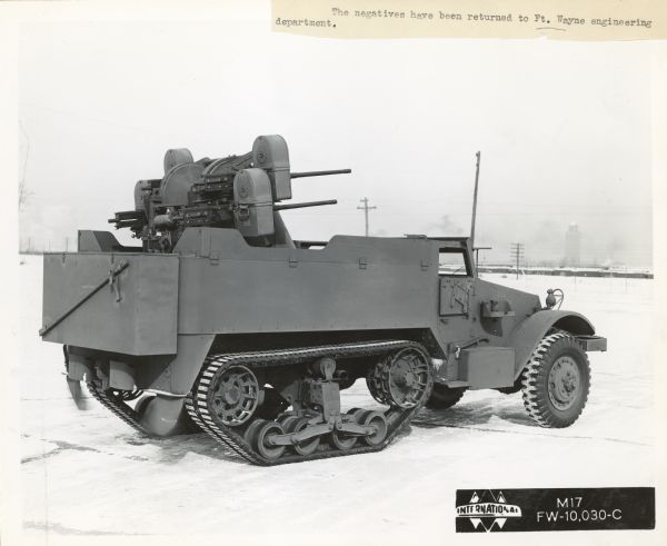 Three-quarter rear view of the right side of an International Harvester half-track M17 parked outdoors.