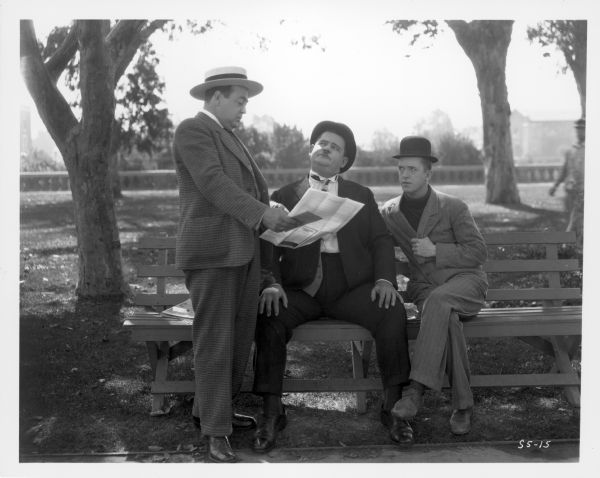 Oliver Hardy and Stan Laurel are sitting on a park bench and listening to the insurance agent (Eugene Pallette) as he explains an insurance policy he is trying to sell Hardy, covering Laurel who is a boxer. Laurel and Hardy are looking at him suspiciously. The still is from the 1927 short "Battle of the Century."