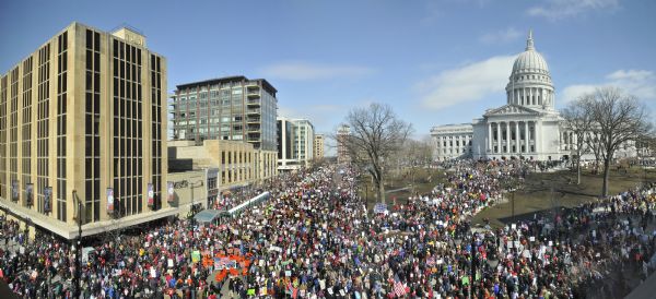 Elevated view of a large crowd gathered on the Capitol Square to protest the passage of the Act 10 bill and greet the return of the 14 Senate Democrats who left the state in an attempt to delay passage of the bill.<p>On the day before this protest, Gov. Scott Walker signed into law the proposal that eliminated most union rights for public employees, saying he had "no doubt" that support for the measure would grow over time.<p>The governor's signature on the bill quietly concluded a debate over collective bargaining that provoked three weeks of loud, relentless protests at the Capitol.<p>The governor insisted the proposal was necessary to balance the state budget. The drama touched off an intense national debate over labor rights for public employees.</p>