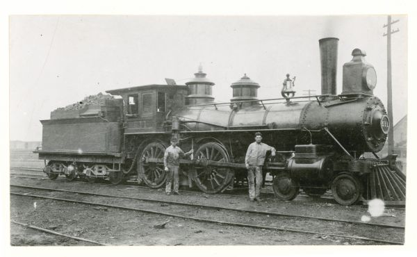 Engineer Daniel Sage and fireman Omro B. Mills standing next to Chicago, Milwaukee, and St. Paul Railway Engine No. 511. The locomotive was formerly No. 626. 