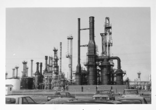 View over parked cars towards the Superior Refinery, which did business as Murphy Oil Corporation at another time. The oil refinery was located at Stinson and Bardon Avenues.