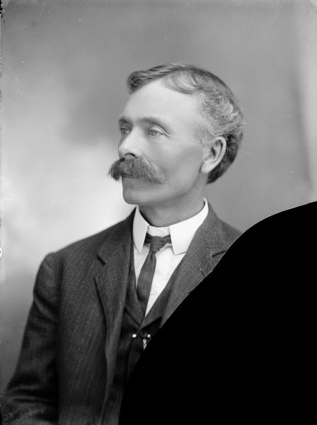 Head and shoulders portrait of William R. Parks, a photographer from Iola, Wisconsin.