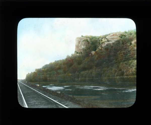 View across Mississippi River towards Maiden Rock. Railroad tracks are in the foreground.