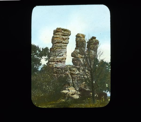 View of the Three Chimneys rock formations, surrounded by trees.