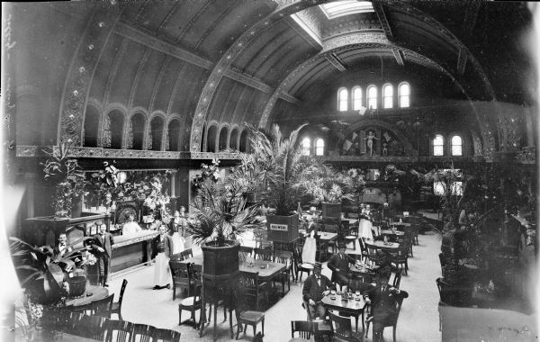 Elevated view of waiters and customers in the Schlitz Palm Garden. The idea of the garden was borrowed from Germany where beer gardens were common. It opened on July 3, 1896. The Schlitz beer garden was one of the most popular and opulent in Milwaukee.  