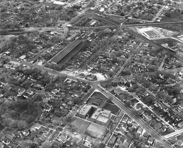 An aerial view, looking northeast, that includes the intersection at Atwood and Fair Oaks Avenues. Elmside Circle Park is on the bottom left. The Madison-Kipp Corporation buildings are across Atwood Avenue in the center. The Lowell Elementary School building is in the center at bottom.