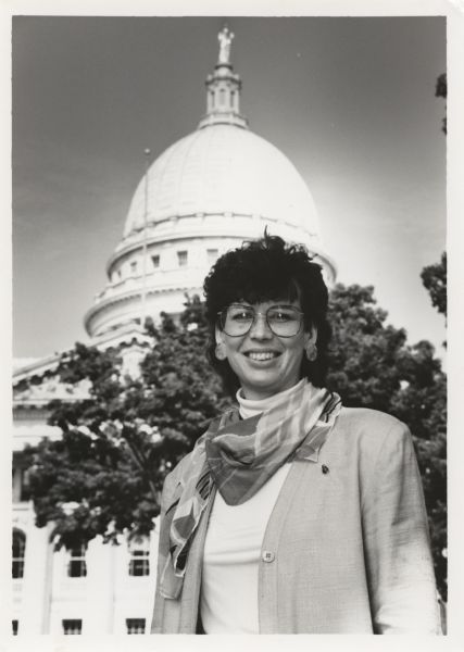 Outdoor portrait of Sheryl Albers, who was the 50th District Representative in the Wisconsin State Assembly, posing in front of the Wisconsin State Capitol building. Ms. Albers was elected Representative in 1991.