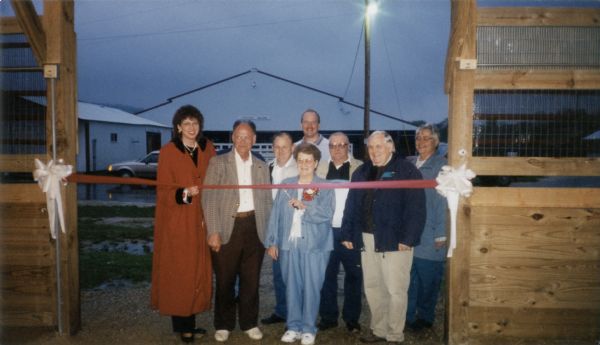 Group portrait of the ribbon-cutting dedication ceremony for the Avery E. Marshall Building, part of the Richland County Fairgrounds. Present are Sheryl Albers, Russell Bernstein, Ken Duncan, Dale Schultz, Jean Marshall, Don Kellogg, Tom McCarthy, and Judy Andresen.