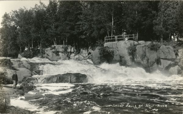 Photographic postcard of Smoky Falls, now called Big Smokey Falls and found within the Menominee Nation. A boy is standing on the left near the falls.