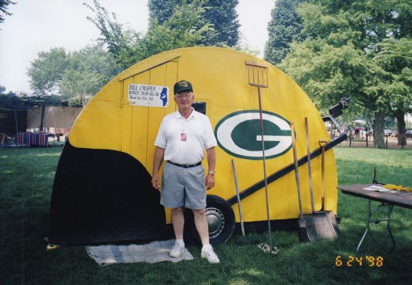 Bill Casper of Fond du Lac, Wisconsin, standing in front of his iconic Green Bay Packers ice shanty. with some of his sturgeon spearing gear during the 1998 Smithsonian Folklife Festival on the National Mall in Washington, D.C. Casper spoke with and gave tours of the shanty to thousands of visitors over a 2-week period.