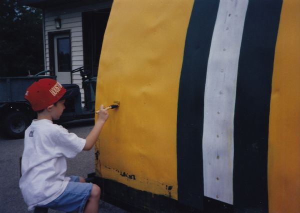 Christian Casper, grandson of Bill Casper, touching up the paint on Bill’s iconic Green Bay Packers ice shanty in Fond du Lac, before it is transported to the 1998 Smithsonian Folklife Festival on the National Mall in Washington, D.C. 