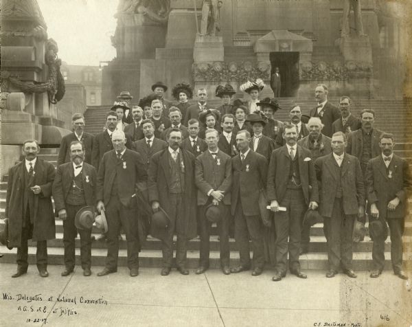 Outdoor group portrait of the Wisconsin delegates at the National Convention of the American Society of Equity, held in Indianapolis. The American Society of Equity was an agricultural cooperative and political organization to organize farmers, so they could compete with capital and organized labor as an economic power. Although the Society merged with the Farmers' Union in 1934, it was the model for future farmer cooperatives.