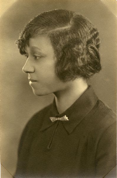 Quarter-length profile portrait of Freddie Mae Hill, the first African-American resident of Madison to graduate from the University of Wisconsin, Madison Home Economics Department. Ms. Hill received her Bachelors of Science degree in home economics in 1928. Her parents were John and Amanda Hill, who owned Hill's Grocery at the intersection of Dayton and Blair.