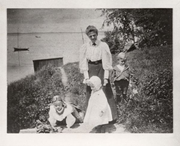 Caroline Mae Sherwood Turner, wife of Frederick Jackson Turner, with their children Dorothy Kinsley Turner, Jackson Allen Turner, and Mae Sherwood Turner at their Frances Street home. Lake Mendota is in the background.