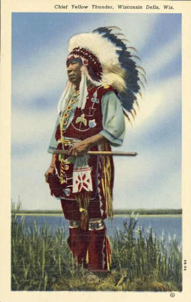 Colorized postcard image of Colonel Chief Albert Yellowthunder of the Ho-Chunk Nation. He is wearing traditional native attire and is holding an object, which may be a pipe. Caption reads: "Chief Yellow Thunder, Wisconsin Dells, Wis."
