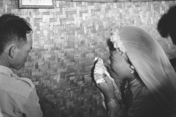 Anh Le Vuong wipes her tears during her wedding to Tien Vinh Le in Binh Hung, Vietnam. A man is standing on the left.