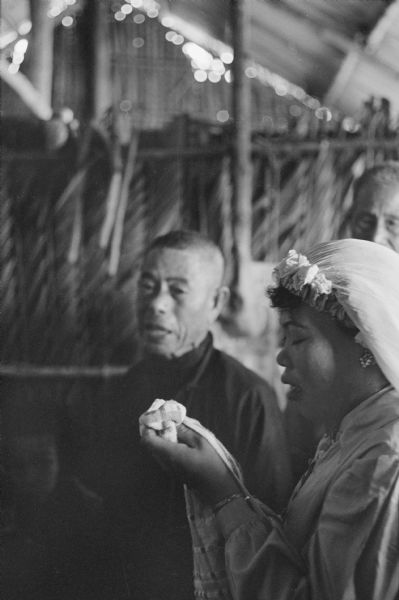 Anh Le Vuong weeps during her wedding in Binh Hung, Vietnam. The officiant behind her is wearing a dark garment.