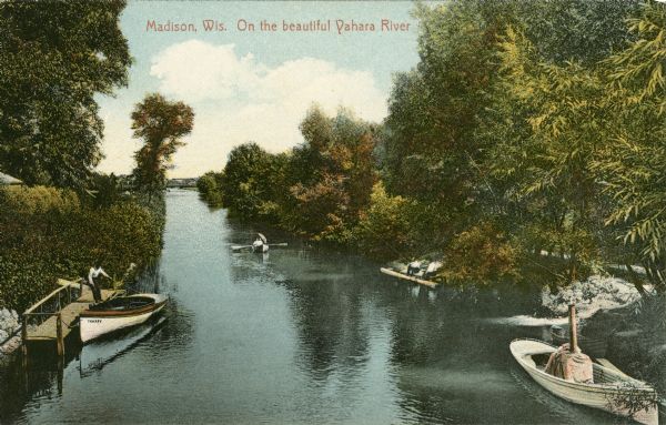 Hand-colored elevated view of the Yahara River. Two people are in a rowboat in the center, and on the right, two people are fishing from a pier along the riverbank. Another man is standing on a pier on the left pulling a rope on a boat named "Yahara." There is a bridge over the river in the distance. Caption reads: "Madison, Wis. On the Beautiful Yahara River."
