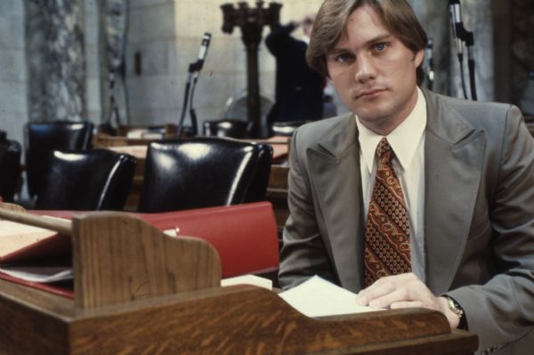 Kevin Soucie was the state representative from the 7th Assembly District, elected in 1974. He is seated facing the camera, with papers and a binder in front of him.