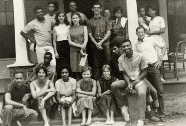 A large group of volunteers pose on the steps in front of the Holly Springs Freedom School.
