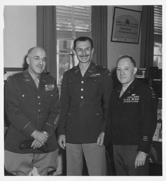 A candid portrait of (left to right) General Oscar Koch, Colonel Hal Forde, and Colonel Robert S. Allen. All of the men are wearing military uniforms.
