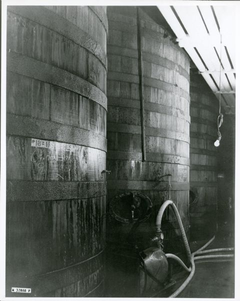 Open-top primary fermentation vats at Fauerbach Brewing Company, used for brewing beer. The wooden vats were made of white oak. There is a pump visible on the floor by the vats. The ovular manholes toward the bottom of the vats provided access into them for cleaning. 