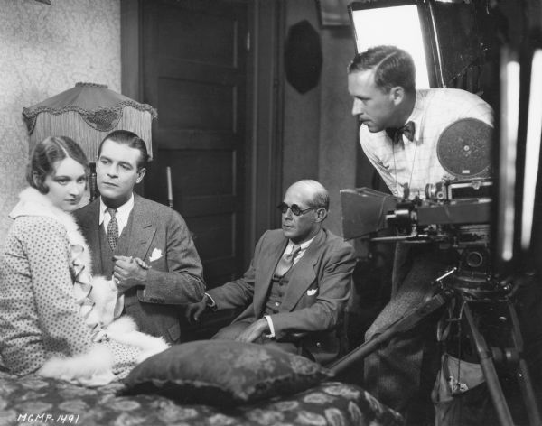 Director John McCarthy watching as Henry Sharp films Eleanor Boardman and Lawrence Gray in a scene from the 1928 film "Diamond Handcuffs."